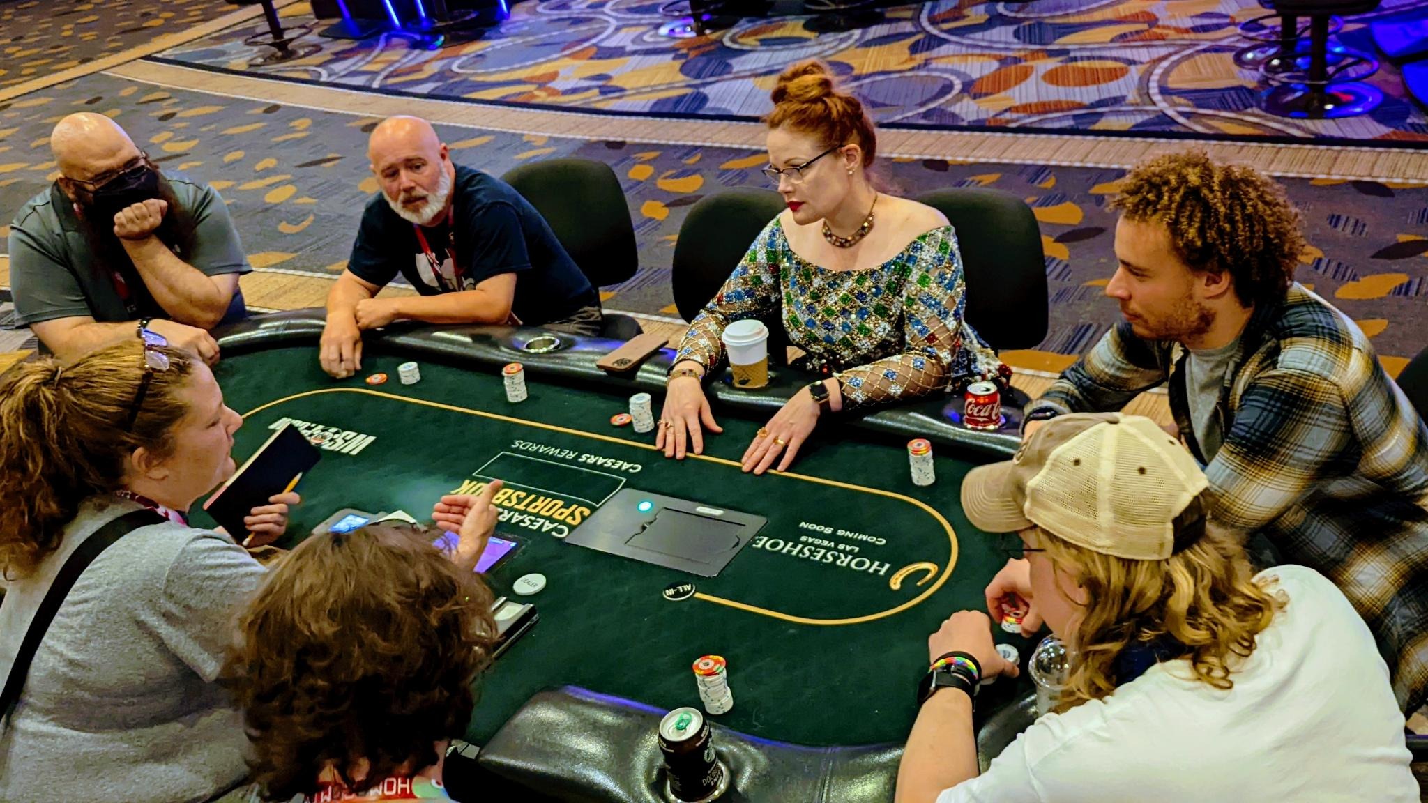 //twitter.com/deviantollam). People listening to someone around a poker table.