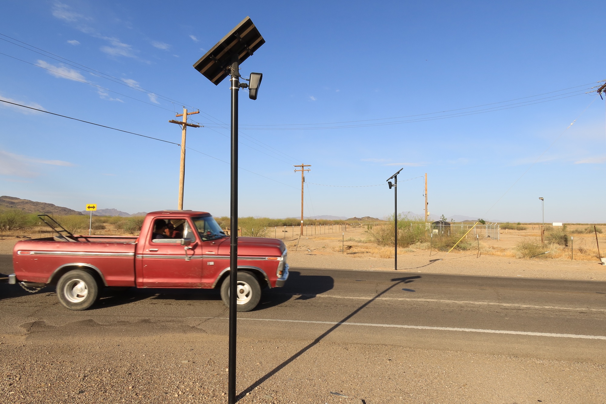 A red truck passed a pair of Flock Safety ALPR cameras on poles. A red truck passed a pair of Flock Safety ALPR cameras on poles.